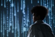 Why Open Source Tools Are Africa’s Best Bet for Digital Independence Side view of a teenager observing futuristic digital code on a screen.